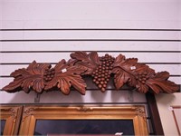 Carved wall decor featuring grapes and