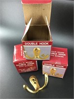 Set of three new in box brass double hooks. All id