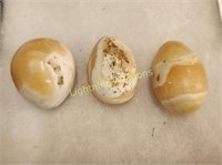 THREE YELLOW CARVED STONE EGGS
