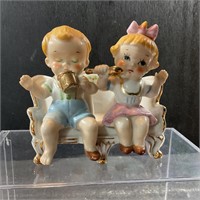 Boy and girl on bench figurine