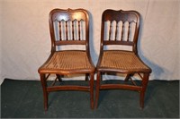 Two spindle back cane seat walnut dining chairs