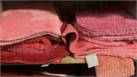 Shelf of pink bathroom rugs