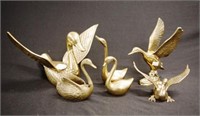 Three brass duck figures with wings outstretched
