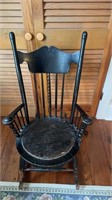 Antique wooden rocker, painted black, with a seat