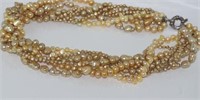 Twisted strands of gold coloured pearls