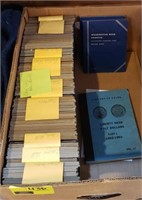 Box of various empty coin collector books