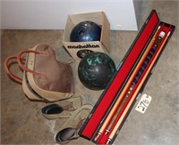 2 bowling balls and a pool stick