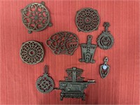 8 Small Cast Iron Trivets and Metal Wall Piece