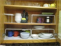 Plates, cups, misc in cabinet right of stove