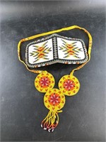 An intricately beaded coin purse with necklace in