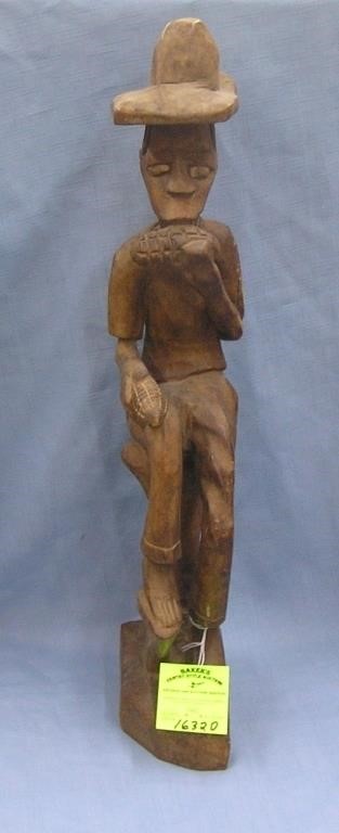 Hand carved African male figure eating corn