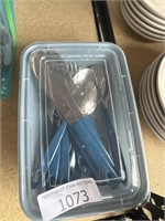 Blue handled silverware in container
