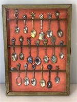 Collection of souvenir spoons in display case