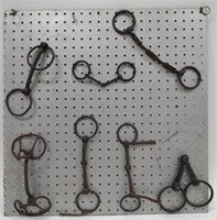 Lot of Vintage Cast Iron Horse Bits on Pegboard