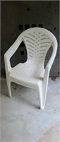 Two white molded plastic stackable patio chairs