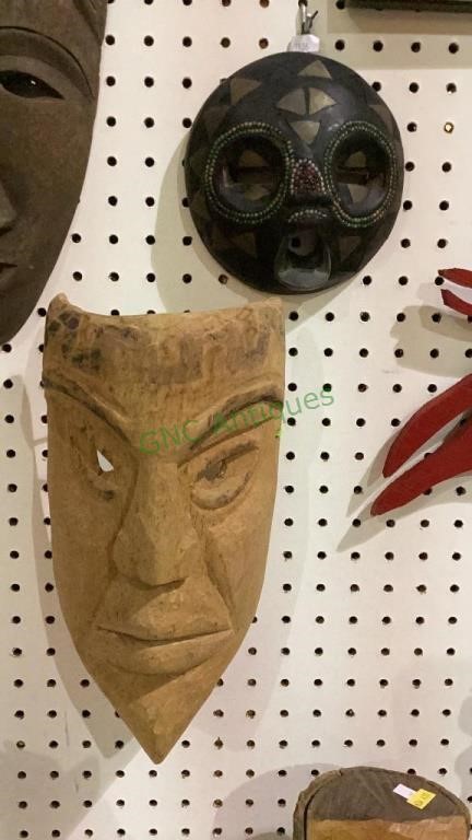 Two wooden masks, the smaller one measures 7