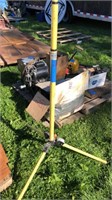 Yellow tripod, pick ax, and pipe bender