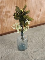 Large glass jug with artificial flowers