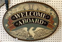 Large oval wooden welcome aboard sign featuring