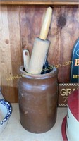 Brown pottery crock with kitchen utensils