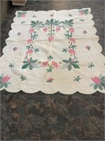 Twin size quilt with flower pattern.
