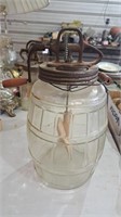 Antique unmarked butter churn sitting on glass