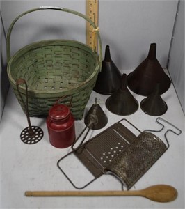 green basket with funnels, graters, potato masher,