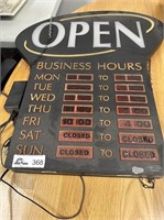 Large lighted, hanging OPEN sign with hours
