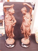 Pair of metal statues depicting scantily clad