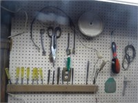 Contents of pegboard on wall:  snips, nutdrivers