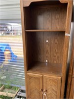 Wooden storage cabinet with doors and shelves in g