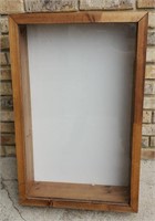 Display case with white wooden backing. About 3'