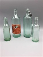 Lot of four Moxie glass advertising bottles