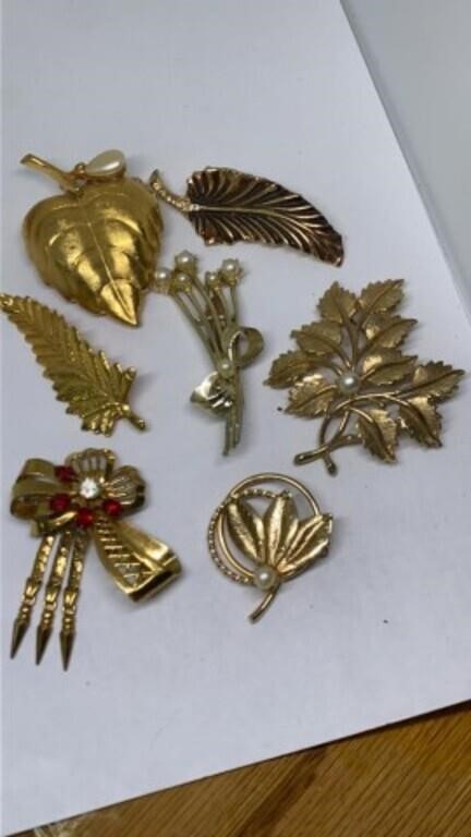 Group of gold tone brooch pins, red one marked