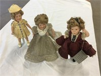 Three Shirley Temple dolls one with a broken arm