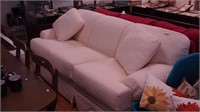 White upholstered three-cushion sofa from