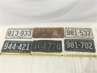 Six vintage license plates.