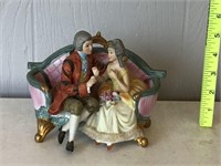 PORCELAIN VICTORIAN COUPLE SITTING ON A SETEE -