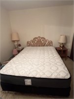 Queen size bed with wicker headboard.