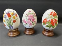 3 Avon porcelain eggs on wood stands 3"h