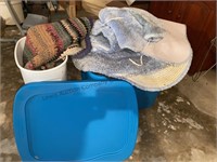 Tote with bath mats & plastic bin with area rug.