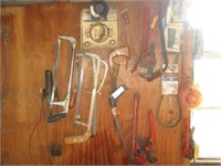 Saws, pipe wrenches and other items on wall