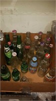 Box with 21 vintage pop bottles most with the