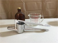 Metal juicer, pyrex measuring cup, maple syrup