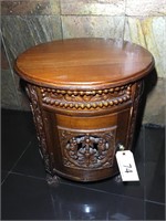 Round wood accent table with storage cabinet.
