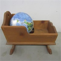 Wood cradle for doll and globe puzzle.
