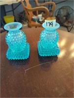 2 blue Fenton bottles sitting on coaster