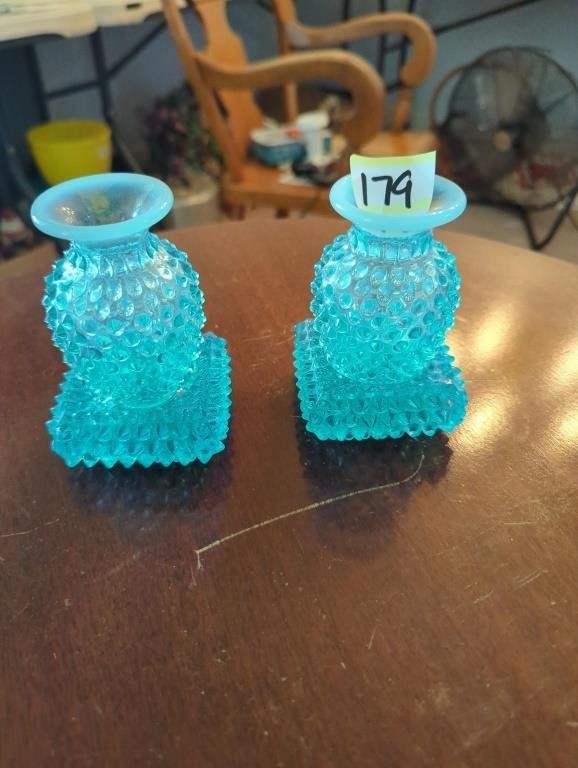 2 blue Fenton bottles sitting on coaster