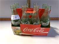 8 Coke bottles in cardboard holder