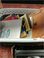 Plastic bin of assorted office supplies